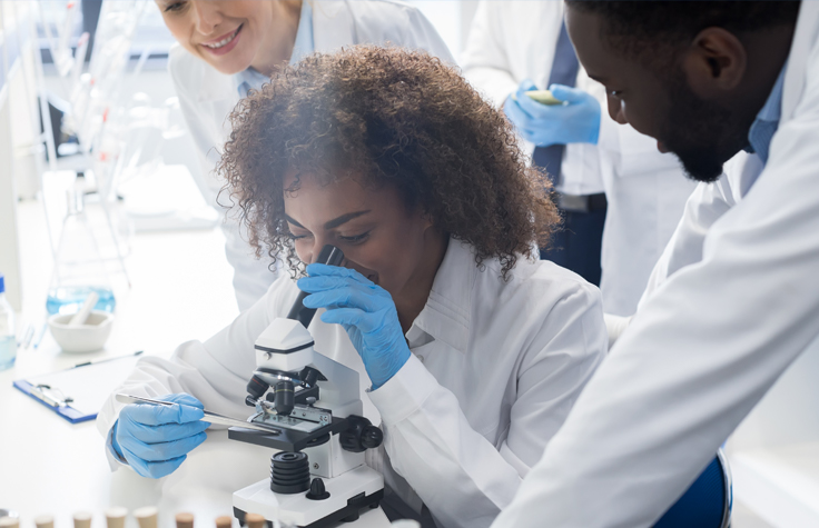 Female scientists looking through microscope