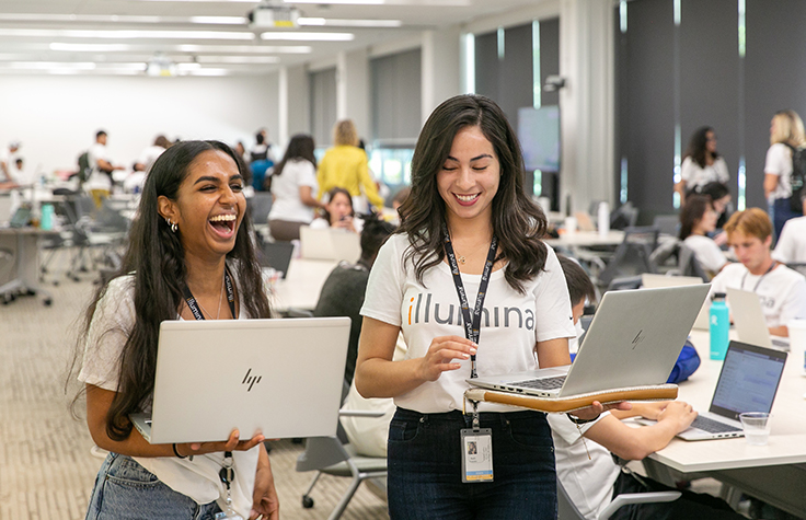 happy interns laughing with laptops in-hand